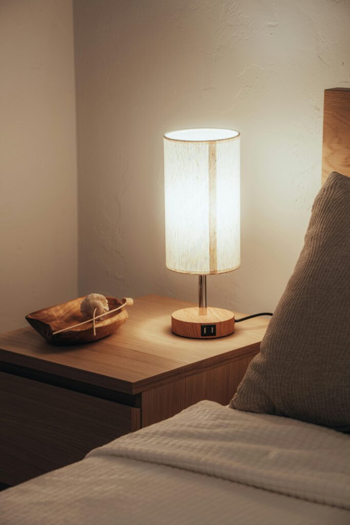 Nightstand bedroom size and style example with a mid height wooden nightstand beside a modern bed in a minimal Canadian bedroom