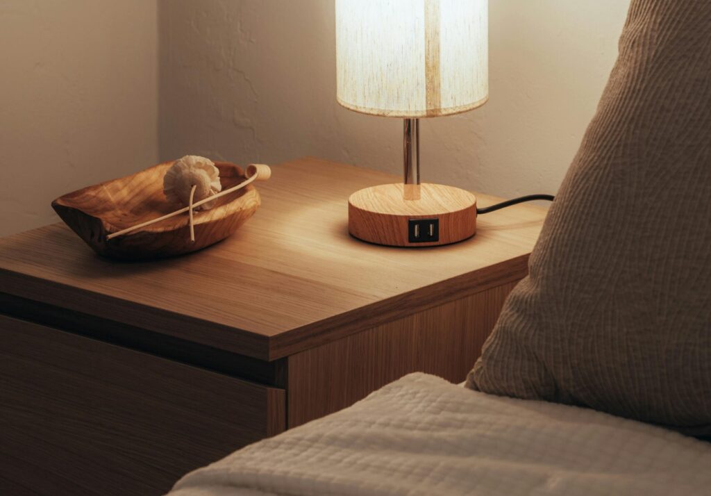 Nightstand bedroom size and style example with a mid height wooden nightstand beside a modern bed in a minimal Canadian bedroom