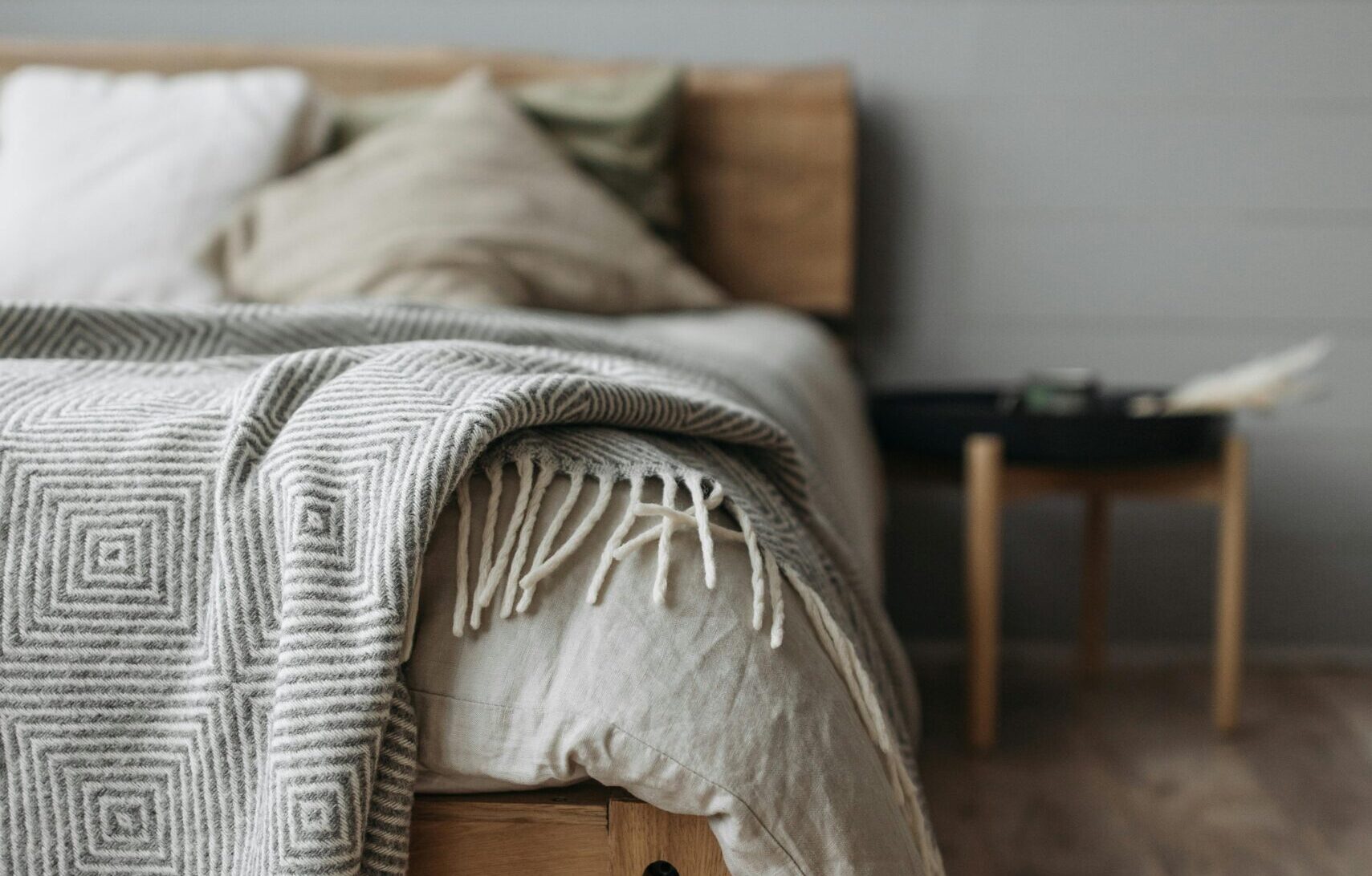 How to buy a bed frame that lasts Canada showing a solid oak platform bed in a bright minimal Canadian master bedroom