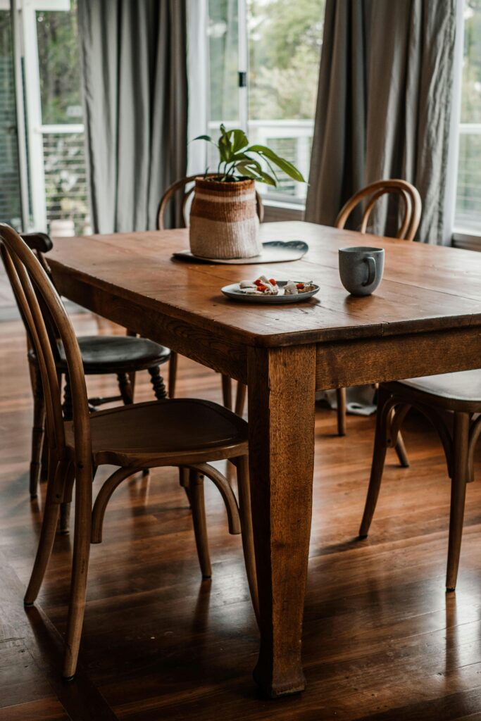 How to choose a dining table for an open concept home in Canada with a round oak table and woven chairs in a bright modern kitchen dining space